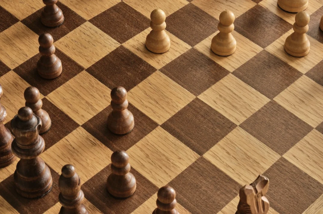 Pawns on a chess piece with dark and light brown colored squares.