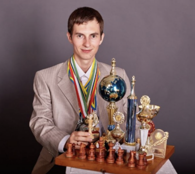 Grandmaster Igor Smirnov posing with a number of trophies and accolades. 