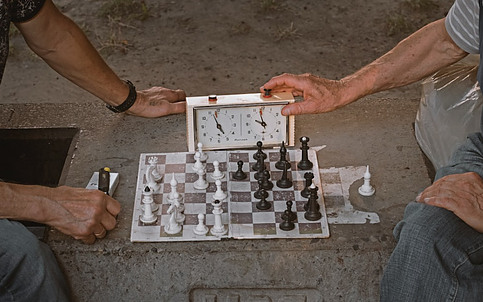 Two men playing a game of chess and using a chess clock.