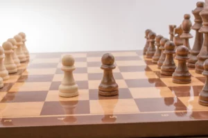 A wooden chess set with a game underway in its opening phase.