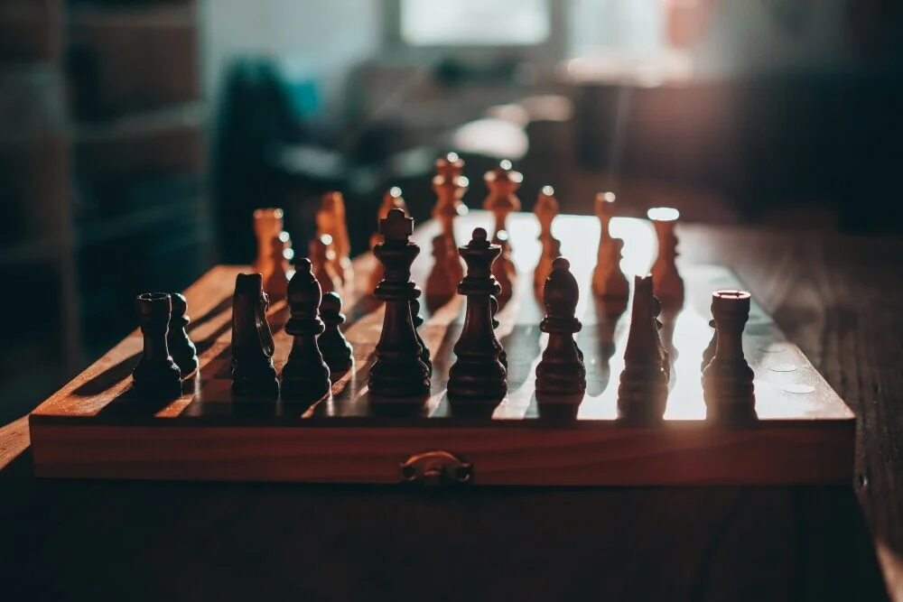 A ray of sunlight shining on an elegant wooden chess set.